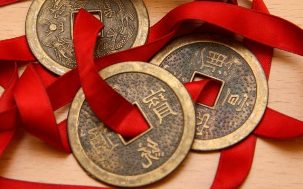 Κινέζικα νομίσματα δεμένα με κόκκινη κορδέλα